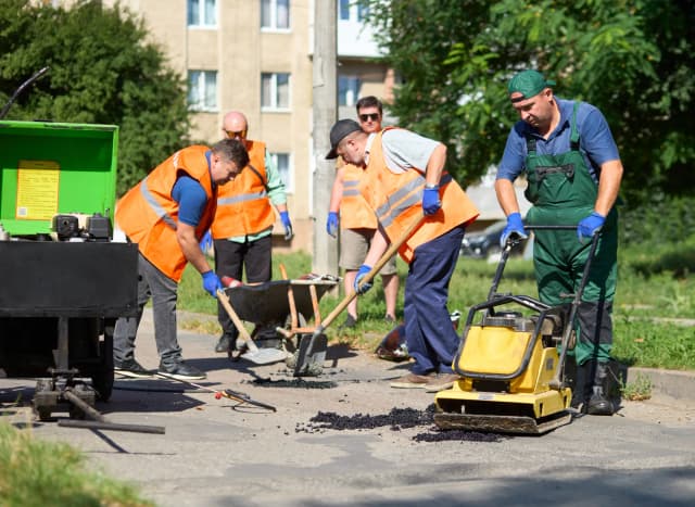 З офісу - у двори: працівники департаменту вийшли латати ями